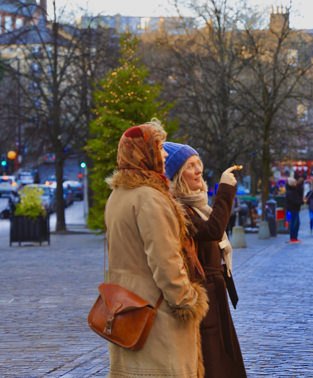 Two women exploring a city street at dusk